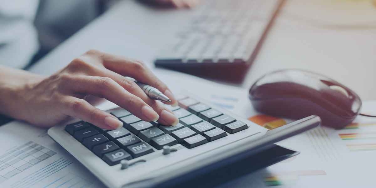 Hands on calculator and keyboard managing cash flow.